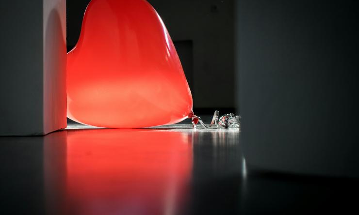 Photo of a heart shaped balloon on the ground to represent a sad or broken heart