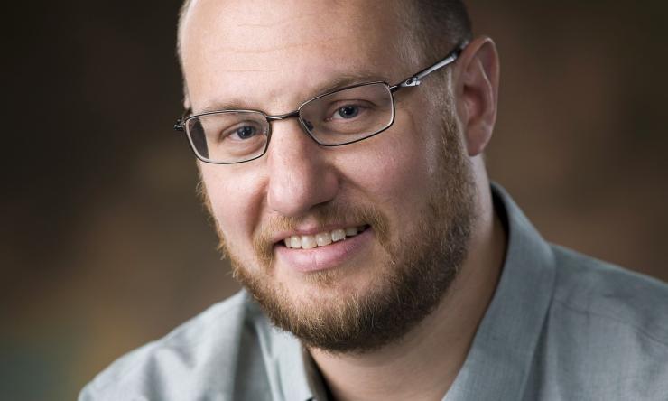 man smiling in front of grey background