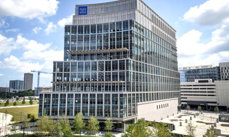 photo of a modern silver building with with a few trees around it