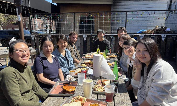 group of people eating lunch at a table outdoors