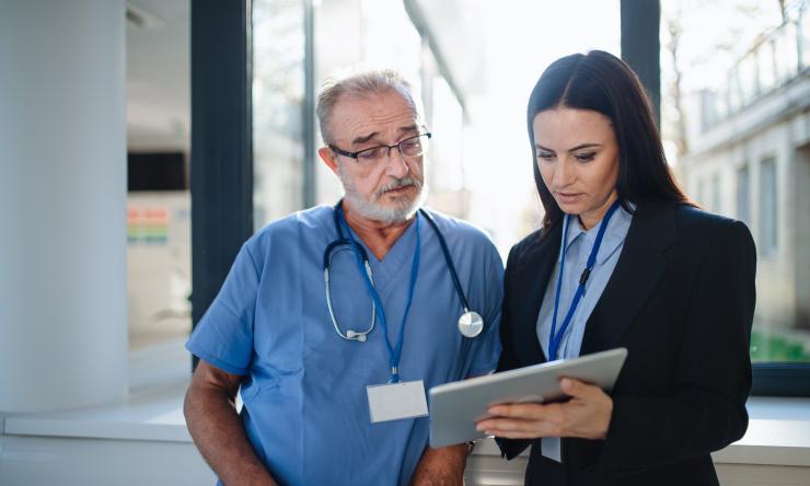 a woman and a doctor looking at a tablet