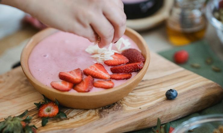 Photo of strawberry yogurt with chopped strawberries and other fruit.