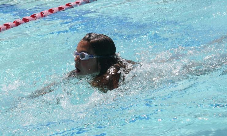 Photo of a young girl swimming wearign goggles.