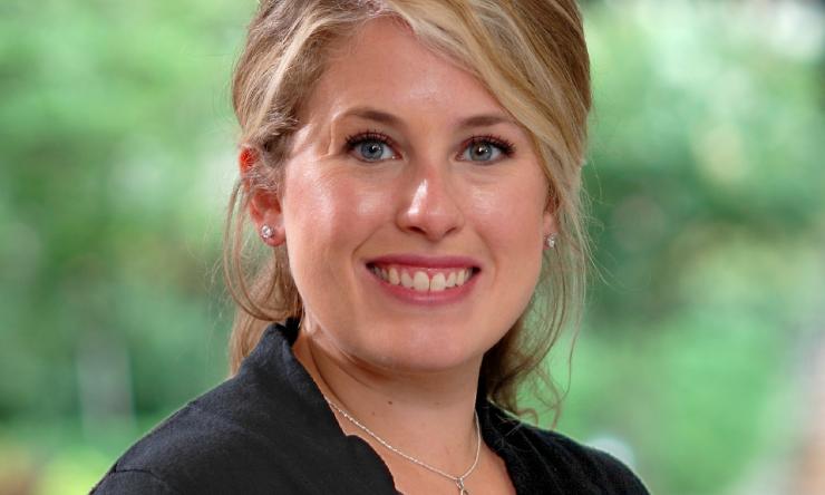 woman with side-parted blonde hair smiling