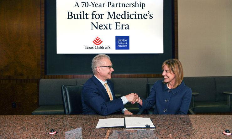 Dr. Jakub Tolar and Dr. Debra Sukin shaking hands while signing the agreement