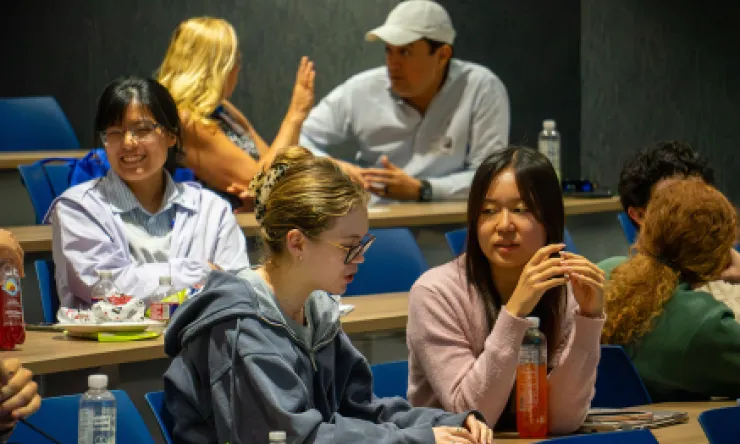 Photo of students talking in an auditorium classroom