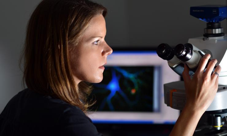Woman at microscope in the light