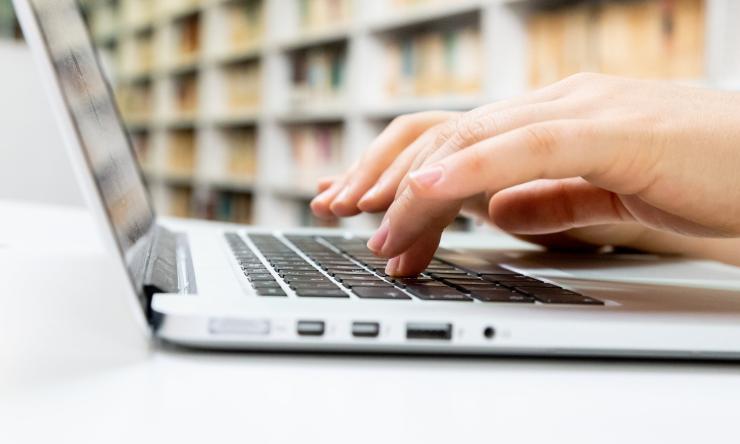 Hands typing on a laptop