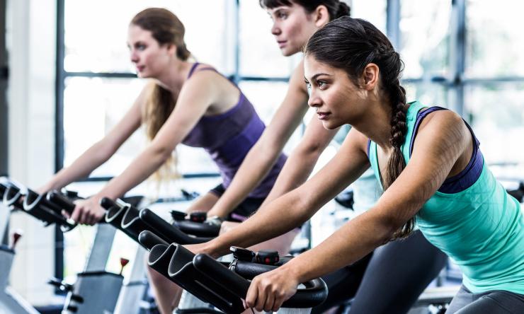 A group of people riding stationary bikes.