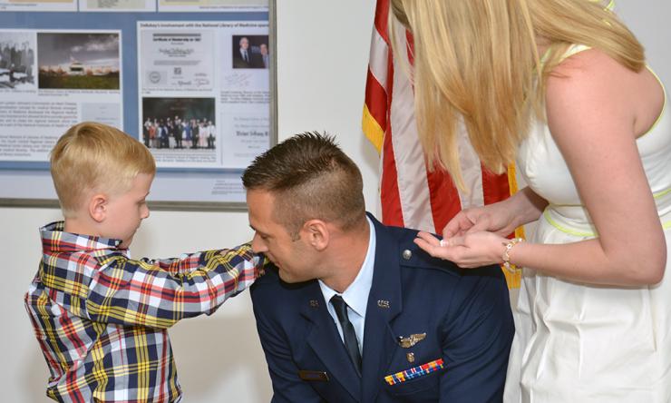 Tim Soeken's son and wife help change his rank during the Military Commissioning Ceremony.